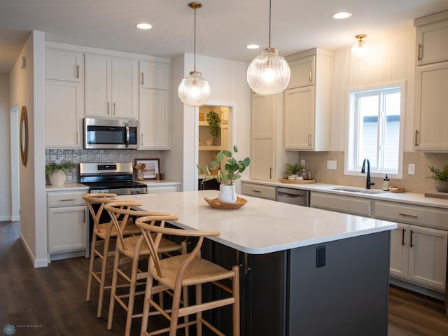 1449 66th Ave S, Fargo, ND 58104 - kitchen with stainless steel appliances, tasteful backsplash, recessed lighting, a kitchen island, and dark wood-style floors