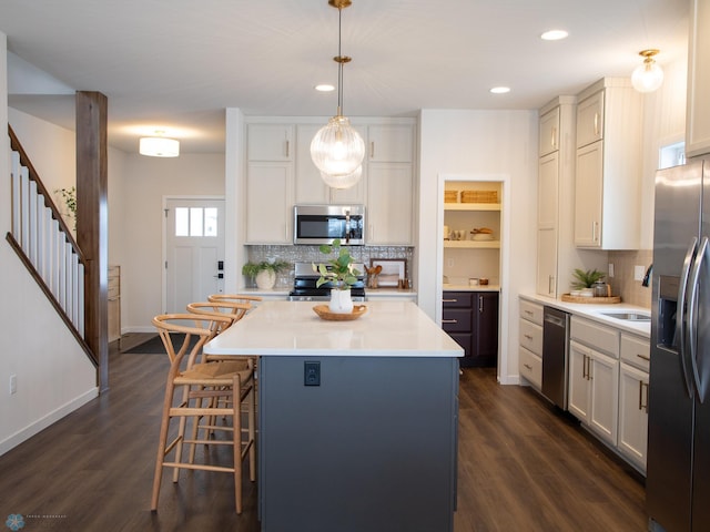 1449 66th Ave S, Fargo, ND 58104 - kitchen with appliances with stainless steel finishes, tasteful backsplash, light countertops, a center island, and recessed lighting