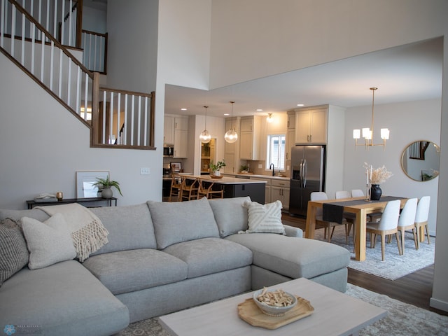 1449 66th Ave S, Fargo, ND 58104 - living room featuring dark wood finished floors, a chandelier, recessed lighting, a towering ceiling, and stairway