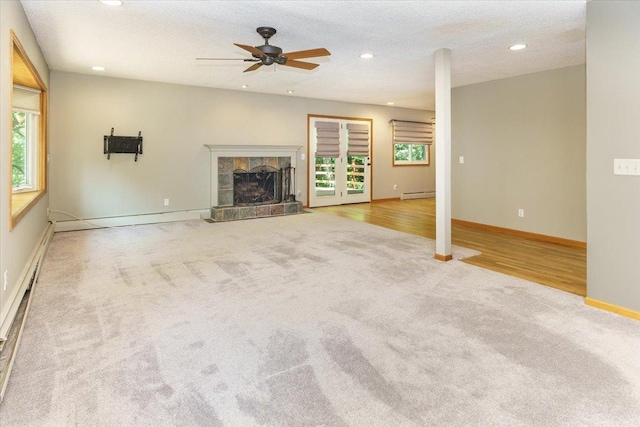 8335 Bush Lake Rd, Bloomington, MN 55438 - unfurnished living room featuring carpet, a baseboard radiator, recessed lighting, a ceiling fan, and a tiled fireplace