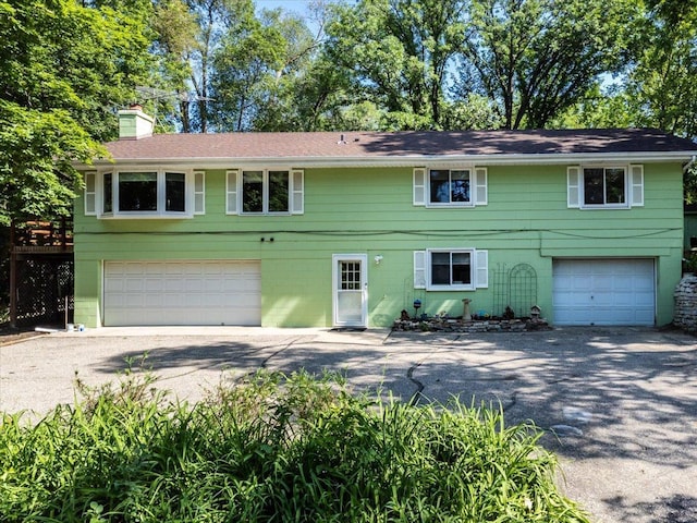 8335 Bush Lake Rd, Bloomington, MN 55438 - view of front of property with a garage, driveway, and a chimney