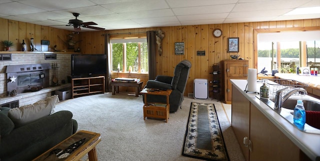 1198 Mink Rd, Ellsburg Twp, MN 55724 - living area with light colored carpet, ceiling fan, wooden walls, and a drop ceiling