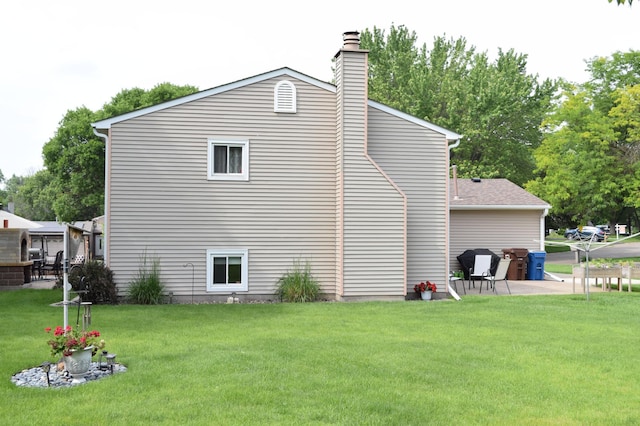 12115 50th Ave N, Plymouth, MN 55442 - view of property exterior featuring a yard, a chimney, and a patio