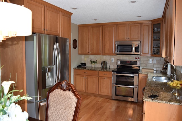12115 50th Ave N, Plymouth, MN 55442 - kitchen with appliances with stainless steel finishes, brown cabinetry, light stone counters, and a textured ceiling