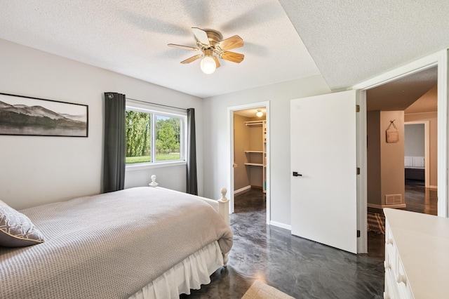 6257 185th Ave SE, Santiago Twp, MN 55308 - bedroom featuring concrete flooring, a textured ceiling, a walk in closet, ceiling fan, and a closet