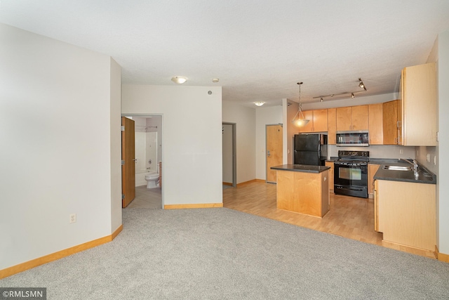 2600 University Ave SE Unit 318, Minneapolis, MN 55414 - kitchen featuring black appliances, dark countertops, a kitchen island, light carpet, and decorative light fixtures