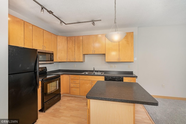 2600 University Ave SE Unit 318, Minneapolis, MN 55414 - kitchen featuring black appliances, dark countertops, light wood-type flooring, and decorative light fixtures