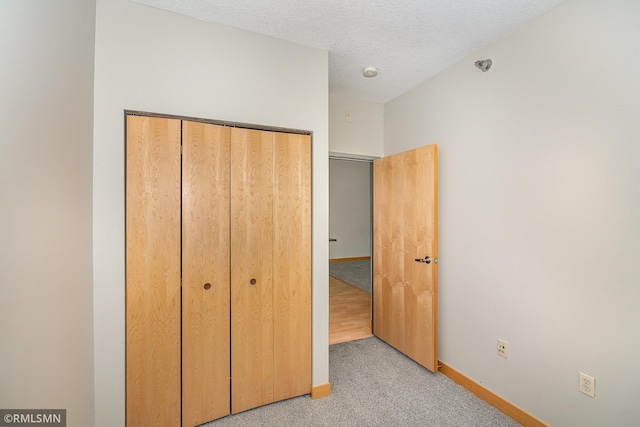 2600 University Ave SE Unit 318, Minneapolis, MN 55414 - unfurnished bedroom featuring carpet floors, a closet, and a textured ceiling