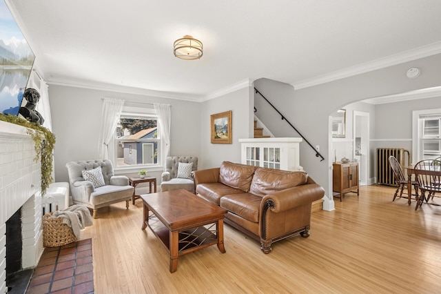 1407 Pascal St N, Saint Paul, MN 55108 - living area with radiator, a fireplace, arched walkways, light wood-type flooring, and ornamental molding
