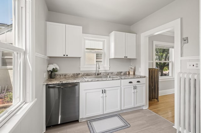 1407 Pascal St N, Saint Paul, MN 55108 - kitchen featuring stainless steel dishwasher, radiator heating unit, white cabinets, and light wood finished floors