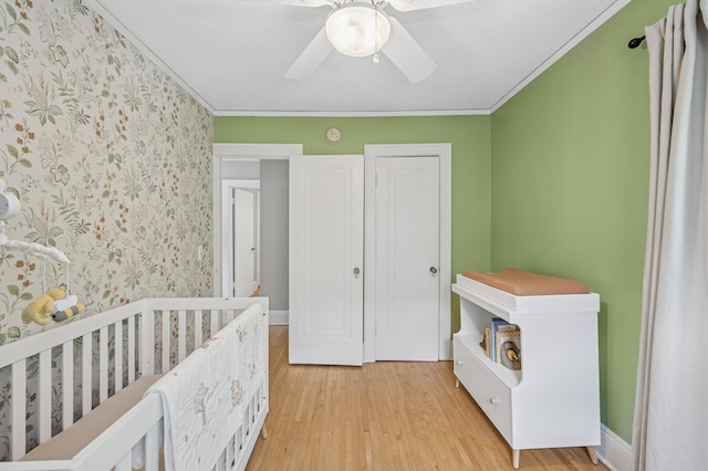 1407 Pascal St N, Saint Paul, MN 55108 - bedroom with light wood-style floors, wallpapered walls, crown molding, and ceiling fan