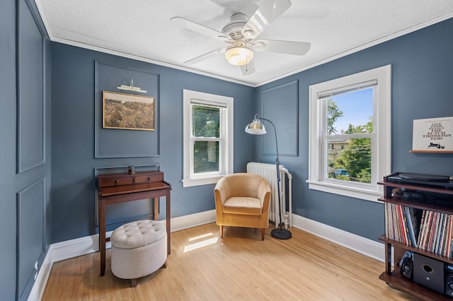 1407 Pascal St N, Saint Paul, MN 55108 - sitting room featuring radiator, a textured ceiling, wood finished floors, crown molding, and ceiling fan