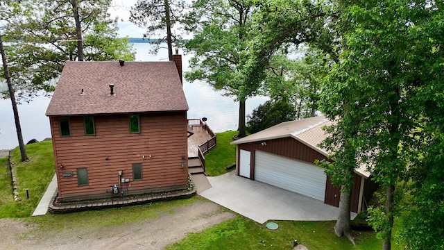 3025 Viewpoint Rd, Isle, MN 56342 - view of home's exterior with an outbuilding, a chimney, a detached garage, and a lawn