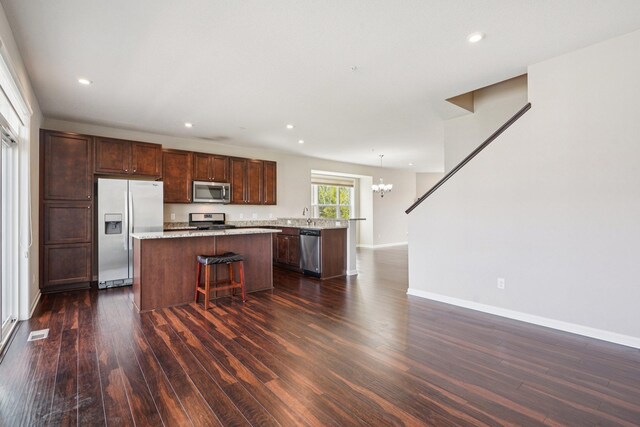 8169 Central Park Way N, Maple Grove, MN 55369 - kitchen with stainless steel appliances, a kitchen island, a chandelier, dark wood-style floors, and recessed lighting