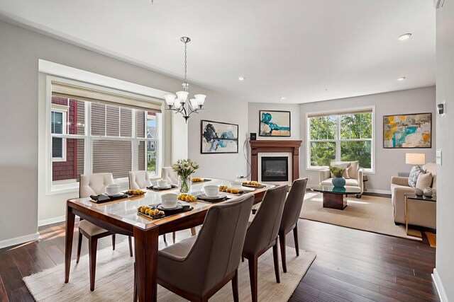 8169 Central Park Way N, Maple Grove, MN 55369 - dining space with wood-type flooring, a glass covered fireplace, a chandelier, and recessed lighting
