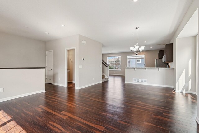 8169 Central Park Way N, Maple Grove, MN 55369 - unfurnished living room with stairway, a chandelier, dark wood-style floors, and recessed lighting