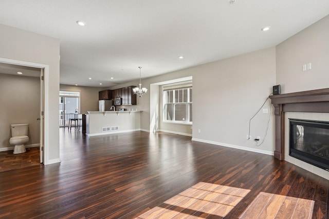 8169 Central Park Way N, Maple Grove, MN 55369 - unfurnished living room with a chandelier, dark wood-type flooring, a fireplace, and recessed lighting