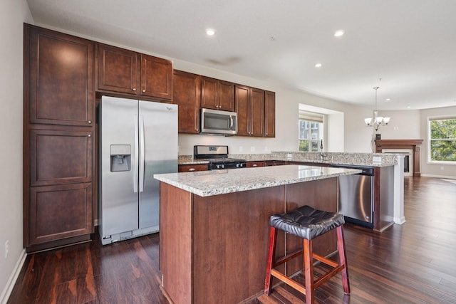 8169 Central Park Way N, Maple Grove, MN 55369 - kitchen featuring appliances with stainless steel finishes, dark wood-style floors, a peninsula, a chandelier, and recessed lighting