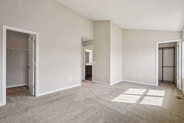8169 Central Park Way N, Maple Grove, MN 55369 - unfurnished bedroom featuring a walk in closet, carpet, a closet, high vaulted ceiling, and connected bathroom