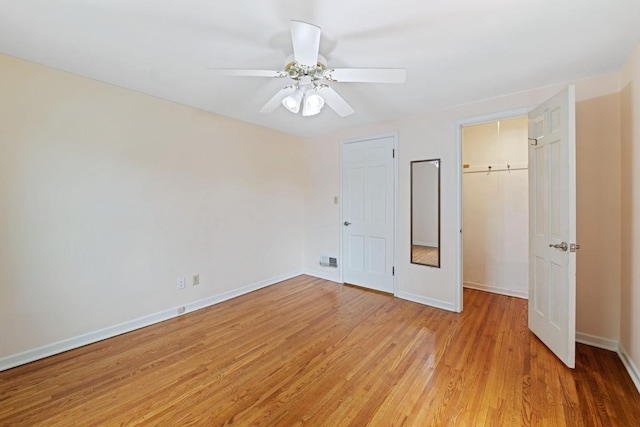 1105 9th Ave NW, Rochester, MN 55901 - unfurnished bedroom with light wood-type flooring, a ceiling fan, a walk in closet, and a closet