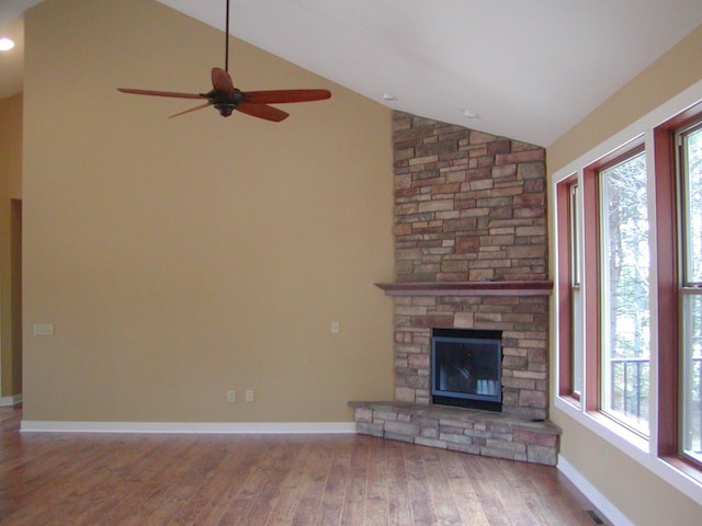 1176X Forestview Dr, Baxter, MN 56425 - unfurnished living room featuring lofted ceiling, wood finished floors, a ceiling fan, and a stone fireplace