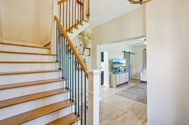 2352 90th Ave, Osceola, WI 54020 - stairs with a barn door, wood finished floors, and ceiling fan
