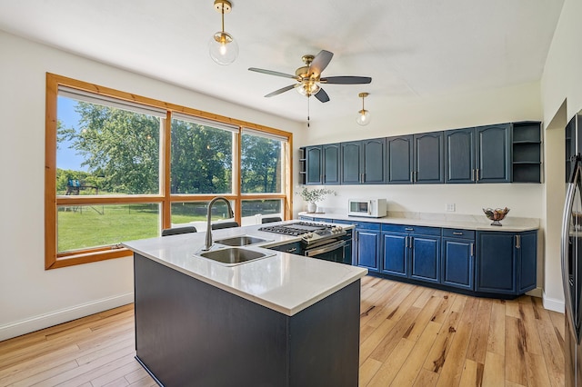 2352 90th Ave, Osceola, WI 54020 - kitchen with gas stove, a ceiling fan, light wood-style floors, blue cabinets, and light countertops