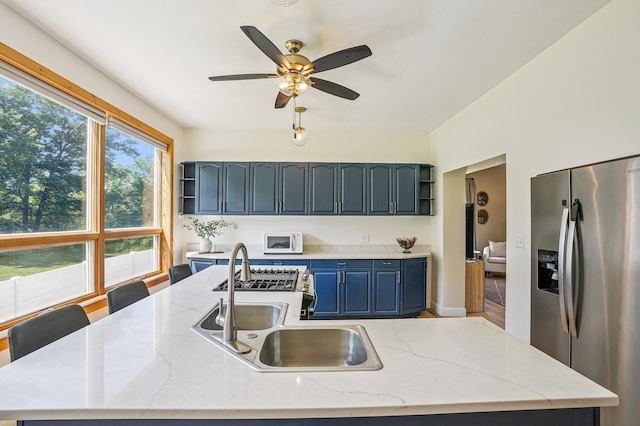 2352 90th Ave, Osceola, WI 54020 - kitchen featuring appliances with stainless steel finishes, open shelves, a kitchen island with sink, and ceiling fan