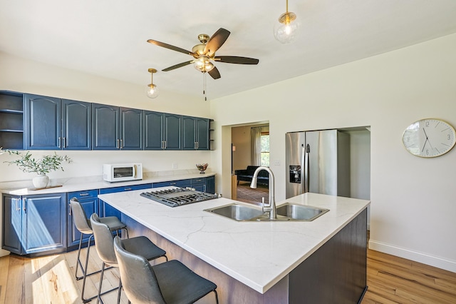 2352 90th Ave, Osceola, WI 54020 - kitchen featuring blue cabinets, appliances with stainless steel finishes, open shelves, ceiling fan, and light wood-type flooring