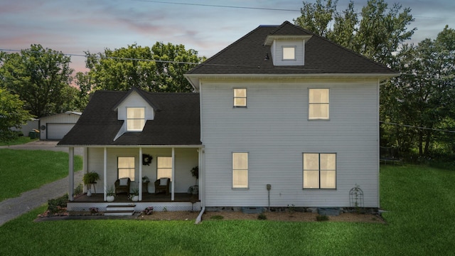 2352 90th Ave, Osceola, WI 54020 - back of house at dusk featuring covered porch, a lawn, and a detached garage