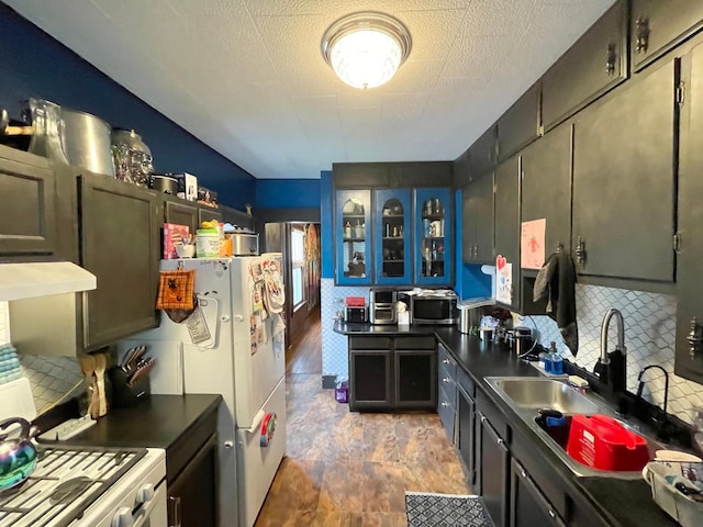 407 Minnesota St, Redwood Falls, MN 56283 - kitchen with dark countertops, range hood, stainless steel microwave, glass insert cabinets, and stone finish floors