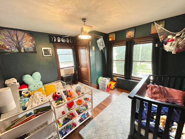 407 Minnesota St, Redwood Falls, MN 56283 - bedroom with radiator heating unit, multiple windows, and wood finished floors