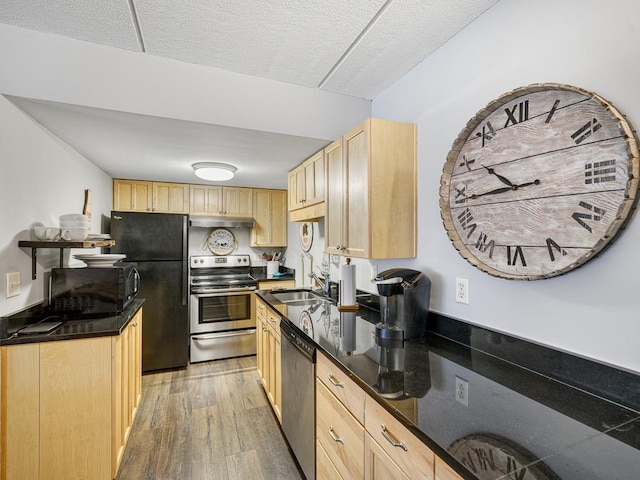 2700 44th St Unit 116, Minneapolis, MN 55410 - kitchen with black appliances, light brown cabinetry, under cabinet range hood, light wood-type flooring, and a textured ceiling