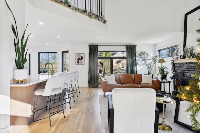 1611 Hill Ridge Ter, Minnetonka, MN 55305 - living room with recessed lighting, a fireplace, light wood-style floors, and a towering ceiling