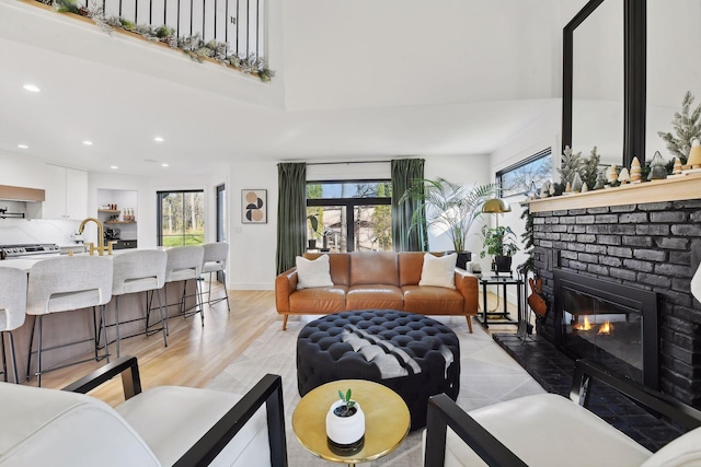 1611 Hill Ridge Ter, Minnetonka, MN 55305 - living room with a fireplace, recessed lighting, a towering ceiling, and light wood finished floors