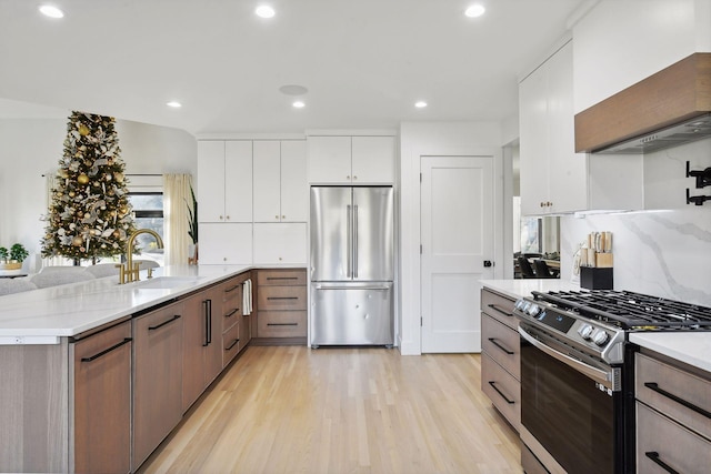 1611 Hill Ridge Ter, Minnetonka, MN 55305 - kitchen featuring stainless steel appliances, light wood finished floors, white cabinets, recessed lighting, and decorative backsplash
