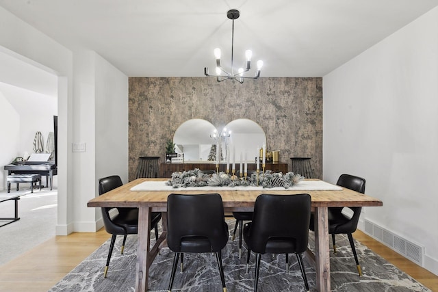 1611 Hill Ridge Ter, Minnetonka, MN 55305 - dining space featuring a chandelier, wood finished floors, and an accent wall