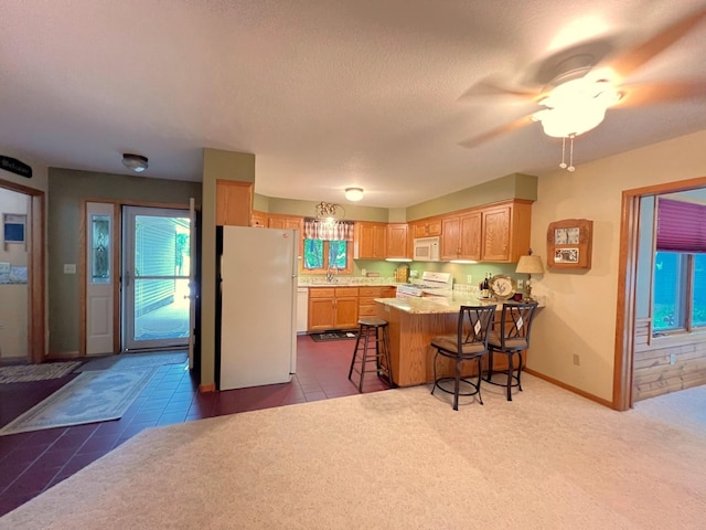 102 Mayfair Ave, New London, MN 56273 - kitchen with white appliances, a peninsula, a kitchen breakfast bar, ceiling fan, and a textured ceiling