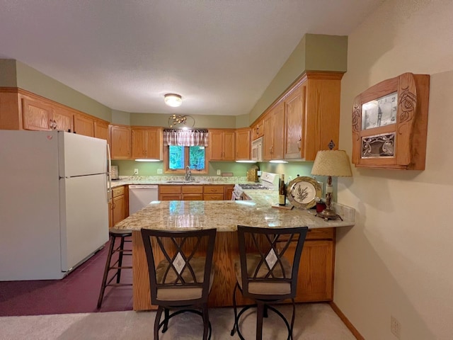 102 Mayfair Ave, New London, MN 56273 - kitchen featuring white appliances, a peninsula, light carpet, a breakfast bar, and light stone countertops
