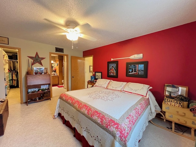 102 Mayfair Ave, New London, MN 56273 - carpeted bedroom with a spacious closet, a closet, a textured ceiling, a ceiling fan, and ensuite bath