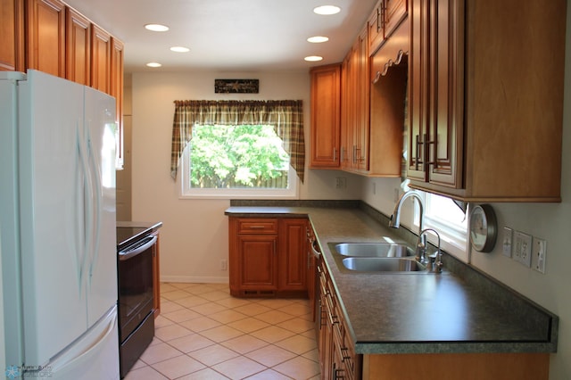 509 24th Ave N, Fargo, ND 58102 - kitchen featuring freestanding refrigerator, stainless steel range with electric cooktop, dark countertops, brown cabinets, and light tile patterned flooring