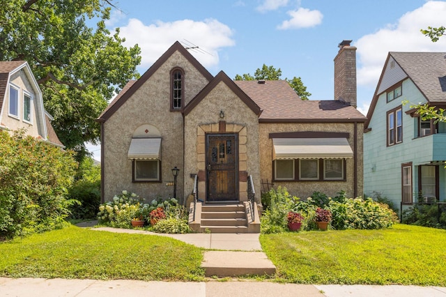 3609 Elliot Ave, Minneapolis, MN 55407 - view of front facade with a front yard, a chimney, and a shingled roof