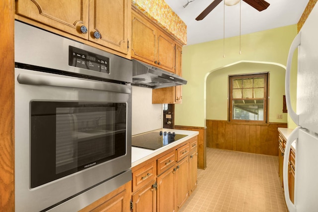 3609 Elliot Ave, Minneapolis, MN 55407 - kitchen with freestanding refrigerator, under cabinet range hood, black electric cooktop, stainless steel oven, and a wainscoted wall