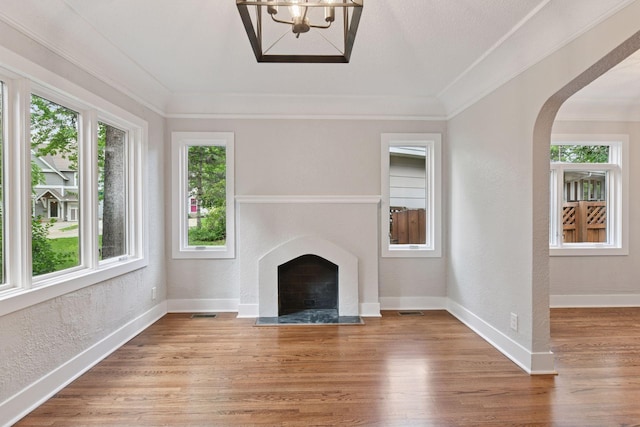 3305 Huntington Ave, Saint Louis Park, MN 55416 - unfurnished living room with a fireplace, a textured wall, a chandelier, light wood-type flooring, and arched walkways