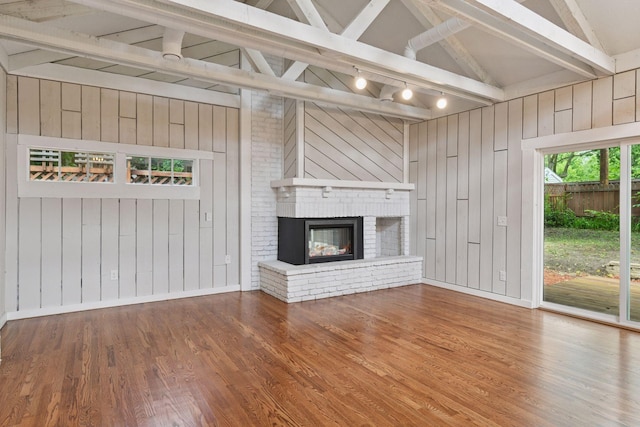 3305 Huntington Ave, Saint Louis Park, MN 55416 - unfurnished living room with wood walls, wood finished floors, a brick fireplace, and track lighting