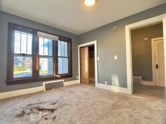 415 College St, Albert Lea, MN 56007 - unfurnished bedroom with carpet, radiator heating unit, and a closet