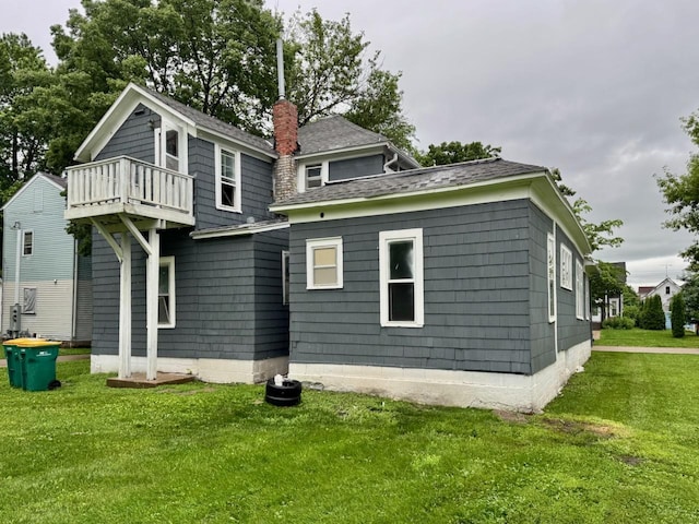 415 College St, Albert Lea, MN 56007 - rear view of property featuring a balcony, a yard, a chimney, and a shingled roof