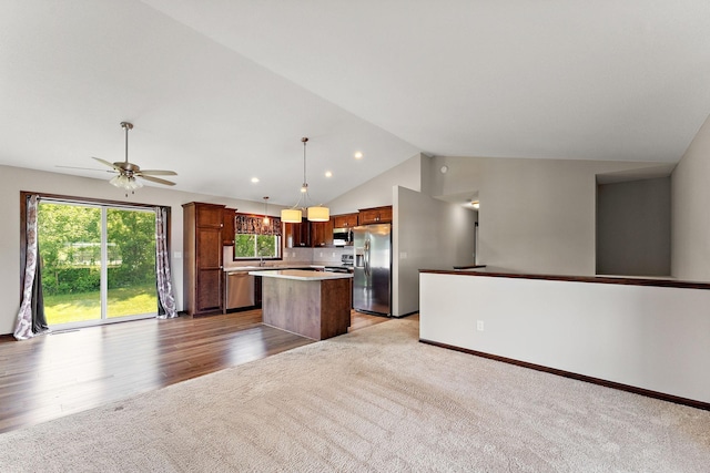 300 Dakota Ave, Roberts, WI 54023 - kitchen with stainless steel appliances, a center island, light carpet, lofted ceiling, and plenty of natural light