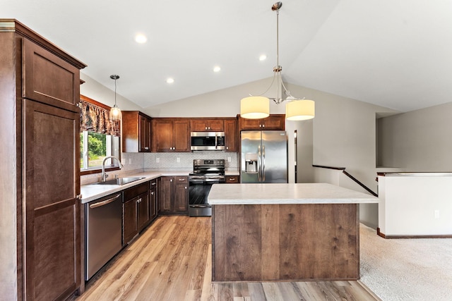 300 Dakota Ave, Roberts, WI 54023 - kitchen featuring stainless steel appliances, light countertops, a kitchen island, vaulted ceiling, and light wood-type flooring
