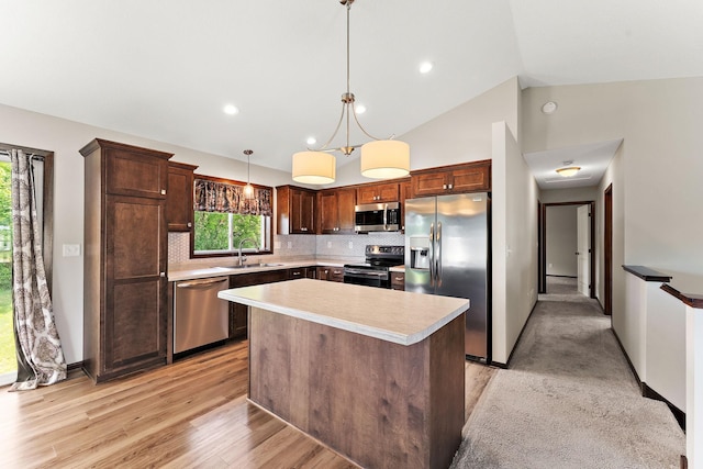 300 Dakota Ave, Roberts, WI 54023 - kitchen featuring appliances with stainless steel finishes, light countertops, backsplash, light wood-style floors, and lofted ceiling